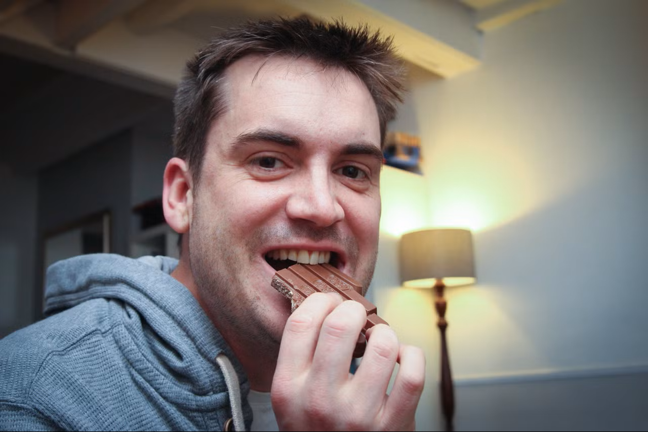 A man eating the Bugdroid KitKat bar