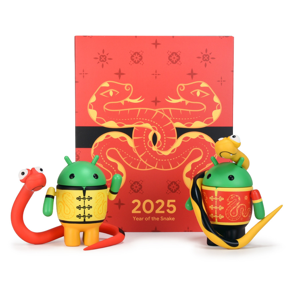 Two chibi roboto figurines with snake accessories standing behind a box