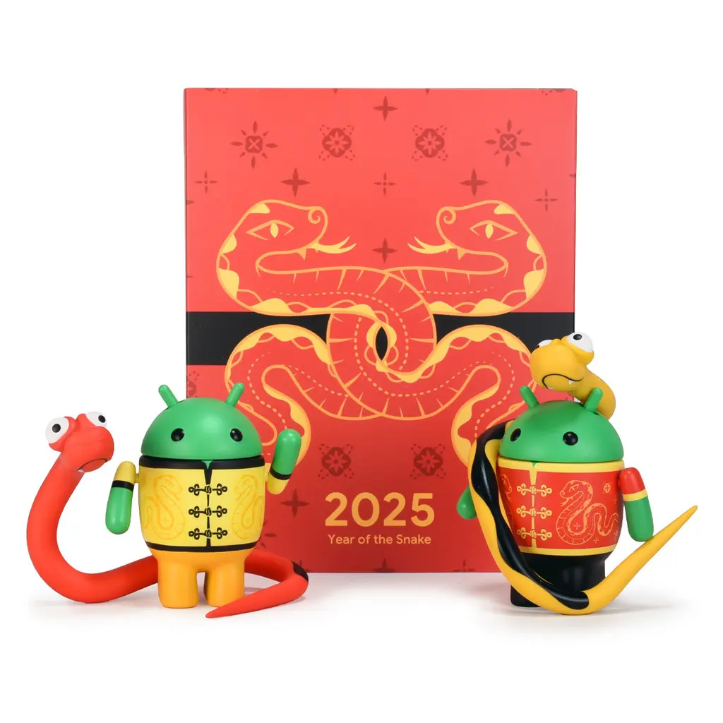 Two chibi bot figurines with snake accessories standing behind a box